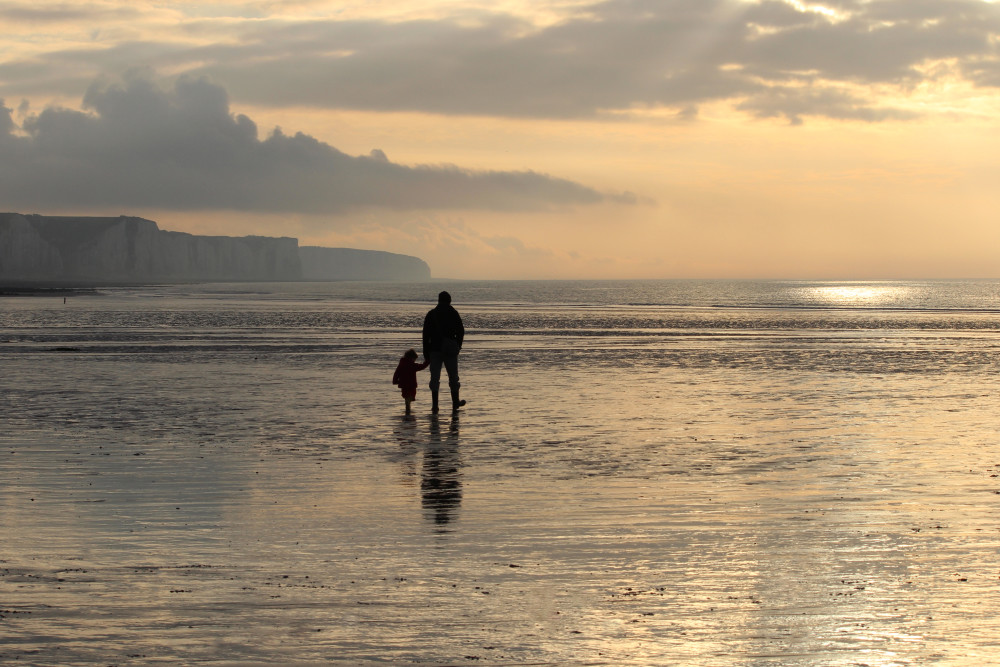 Un père et son fils sur la plage d'Ault juste avant la nuit