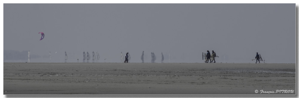 Retour des pêcheurs à pied de la plage de FORT-MAHON avec le mirage des chars à voile en arrière-plan