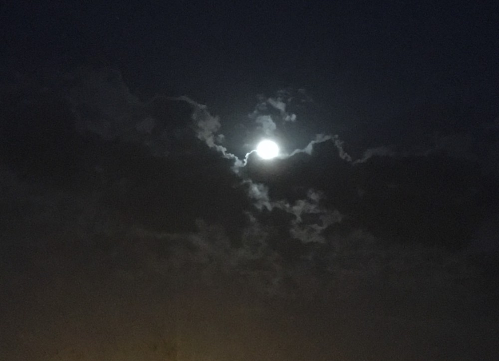 La lune qui se cache derrière les nuages.