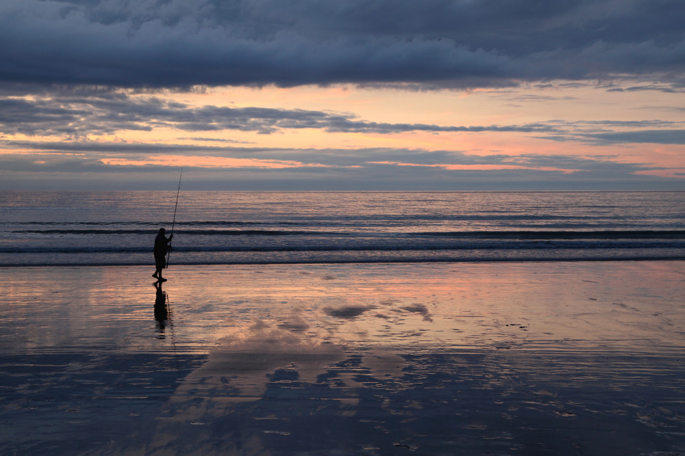 Pêcheur au soleil couchant sur la plage de Mers-les-Bains.