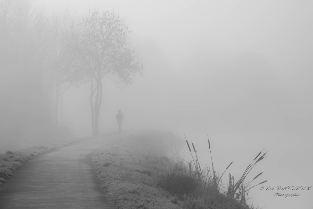 Silhouette de jogger dans la brume, chemin de halage tôt le matin et à la fraiche